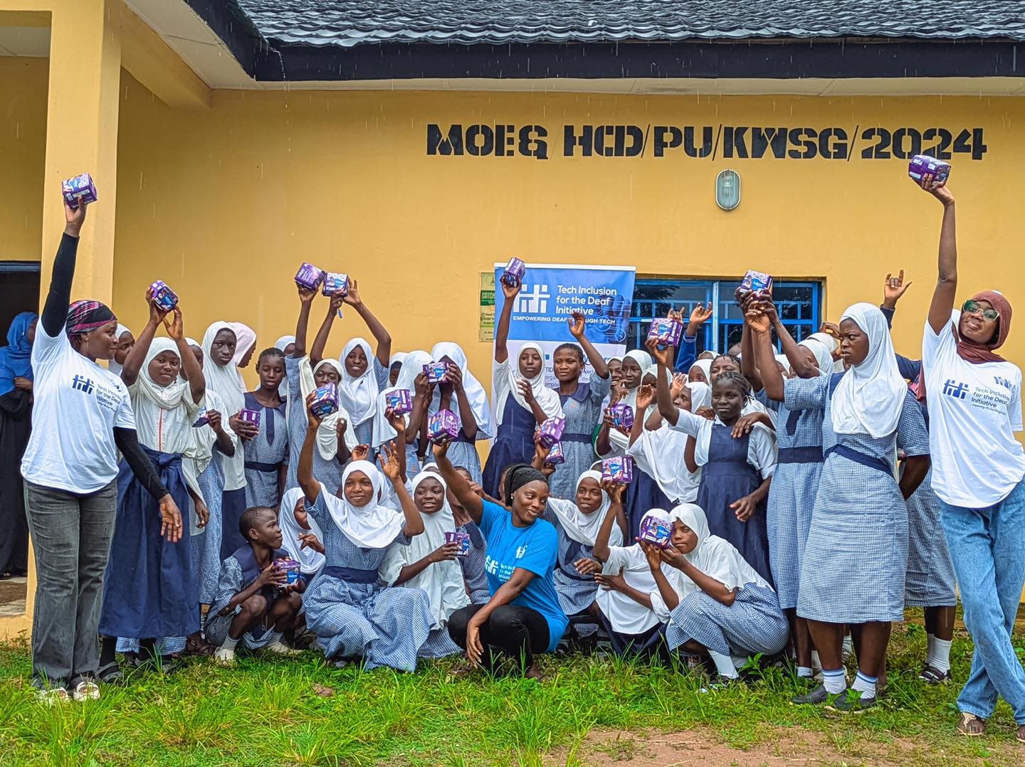 Deaf students and TIDI facilitators holding menstrual health materials after a CODE RED activity